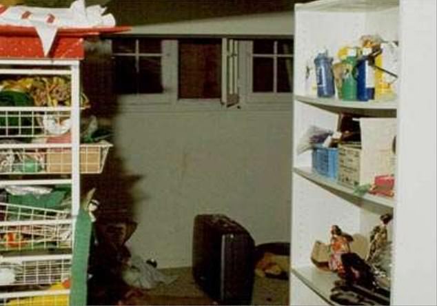 Crime scene photo at the Ramsey family home on December 26, 1996 shows the open basement window which investigators believe JonBenét's killer may have used. Her body was found under a blanket in a neighboring room that had been used as the wine cellar