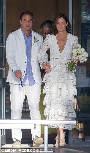 Manteniéndolo tradicional!  la novia deslumbrada con un impresionante vestido de encaje que se cree que es del diseñador de lujo Zimmerman mientras lleva un ramo de flores blancas a juego