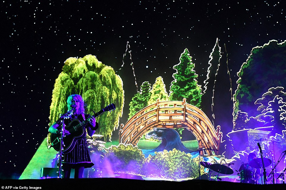 Setting the mood: The singer-songwriter also played in front of a sizable graphic display that showed a curved bridge in front of several trees