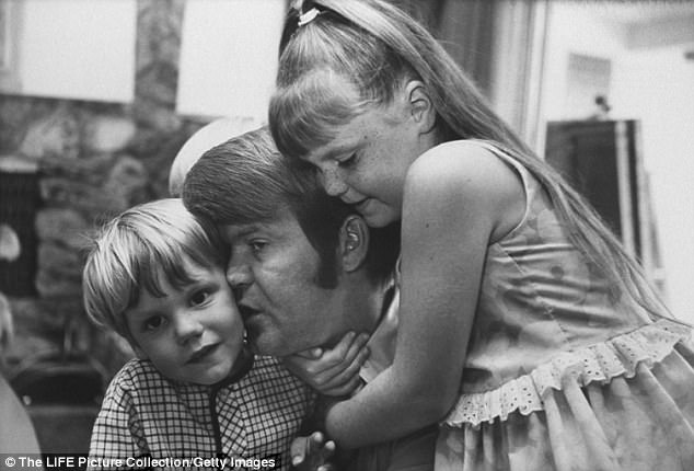 El beso de Campbell es su Travis mientras lo sostiene su hija Kelli en esta foto de la colección de imágenes de LIFE.