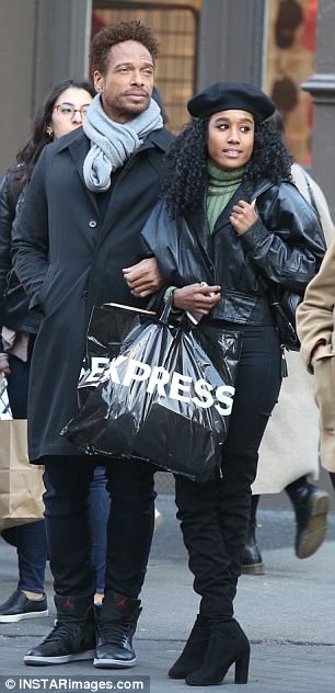 Black Dressed Duo: El ganador del Premio SAG con un abrigo negro, bufanda gris y Nike Air Jordans;  mientras que su mujer misteriosa vestía una chaqueta de cuero recortada con un cuello verde