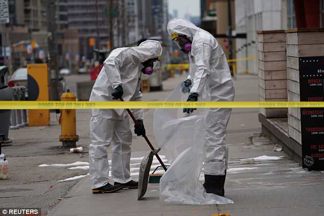 Un equipo de trabajo con ropa protectora despeja una acera un día después de que una camioneta atropelló a varias personas en una intersección importante en el norte de Toronto, Ontario.
