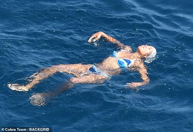 Modo de vacaciones: la Reina, que llevaba un pañuelo blanco sobre el cabello, parecía feliz mientras flotaba en el agua.