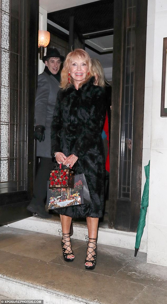 La ex chica Bond Sue Vanner usa un abrigo de piel negro mientras cena con su esposo en el restaurante 34 en Londres.