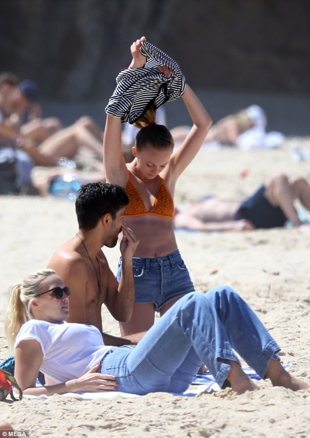 Diversión bajo el sol: Jourdan hizo lo mismo al revelar su figura esbelta y tonificada con la parte superior e inferior de un bikini naranja mientras su amigo se recostaba sobre una toalla.