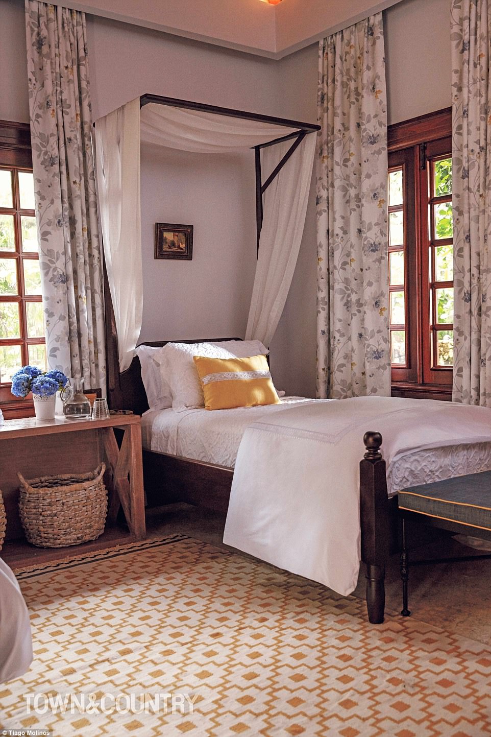 Decoración elegante: uno de los dormitorios de la casa tiene una alegre alfombra amarilla y blanca y cortinas florales. 