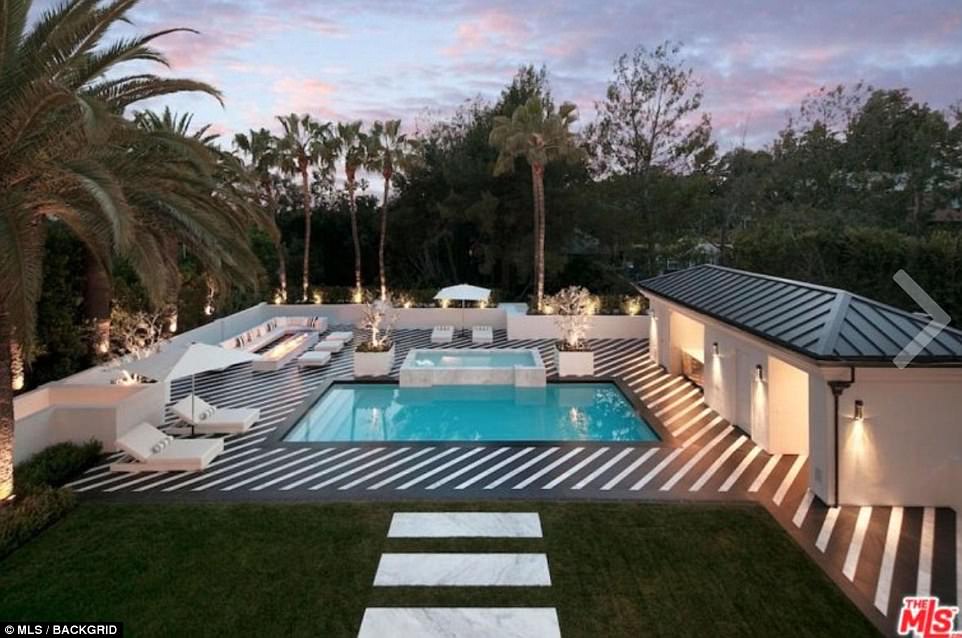 Una vista general del exterior de la mansión de Beverly Hills, que cuenta con una piscina al aire libre y una amplia área de descanso