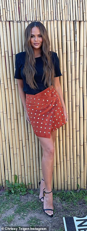 Piernas por días: Chrissy también usó Instagram el sábado para compartir dos nuevas fotos de sí misma, mostrando sus piernas largas y bronceadas con una falda naranja corta adornada con detalles dorados.