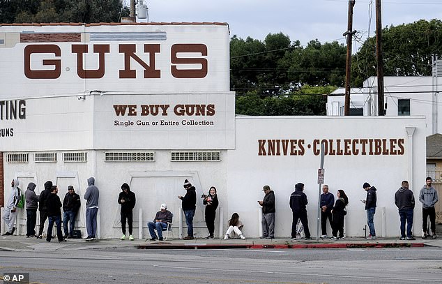 Los estadounidenses están comenzando a entrar en pánico al comprar armas a medida que aumentan las ventas en todo el país y los compradores hacen fila alrededor de la cuadra frente a las tiendas de caza en medio de los temores del coronavirus.  En la foto: los compradores hacen fila afuera de una tienda de armas en Culver City, California