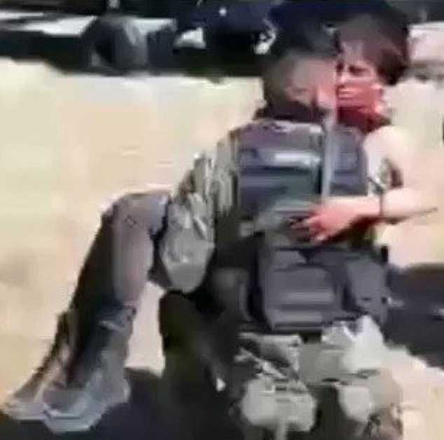 Un soldado se arrodilla mientras sostiene a la herida María Guadalupe López Esquivel momentos antes de ser trasladada en avión a un hospital donde fue declarada muerta.