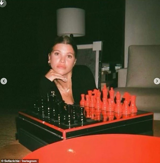 Impresionante: mostrando sus habilidades como modelo, Richie también posó para un retrato estoico frente a un elegante juego de ajedrez rojo y negro.