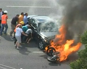 Motociclista debajo de un auto en llamas - video de YouTube
