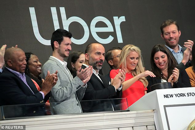 El director ejecutivo de Uber Technologies Inc., Dara Khosrowshah (centro), se encuentra con Austin Geidt (en rojo) cuando suena la campana para abrir la sesión de negociación en la Bolsa de valores de Nueva York.