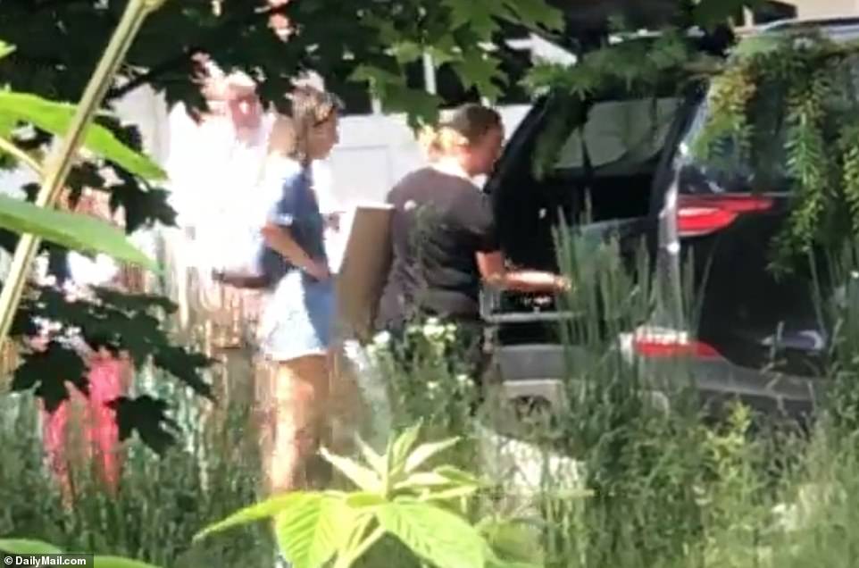 Una mujer que se cree que es Michelle Troconis (de azul) fue vista en la casa de Fotis Dulos Farmington el jueves empacando cosas en un automóvil.